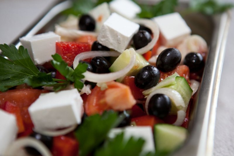 Греческий салат на белом столе