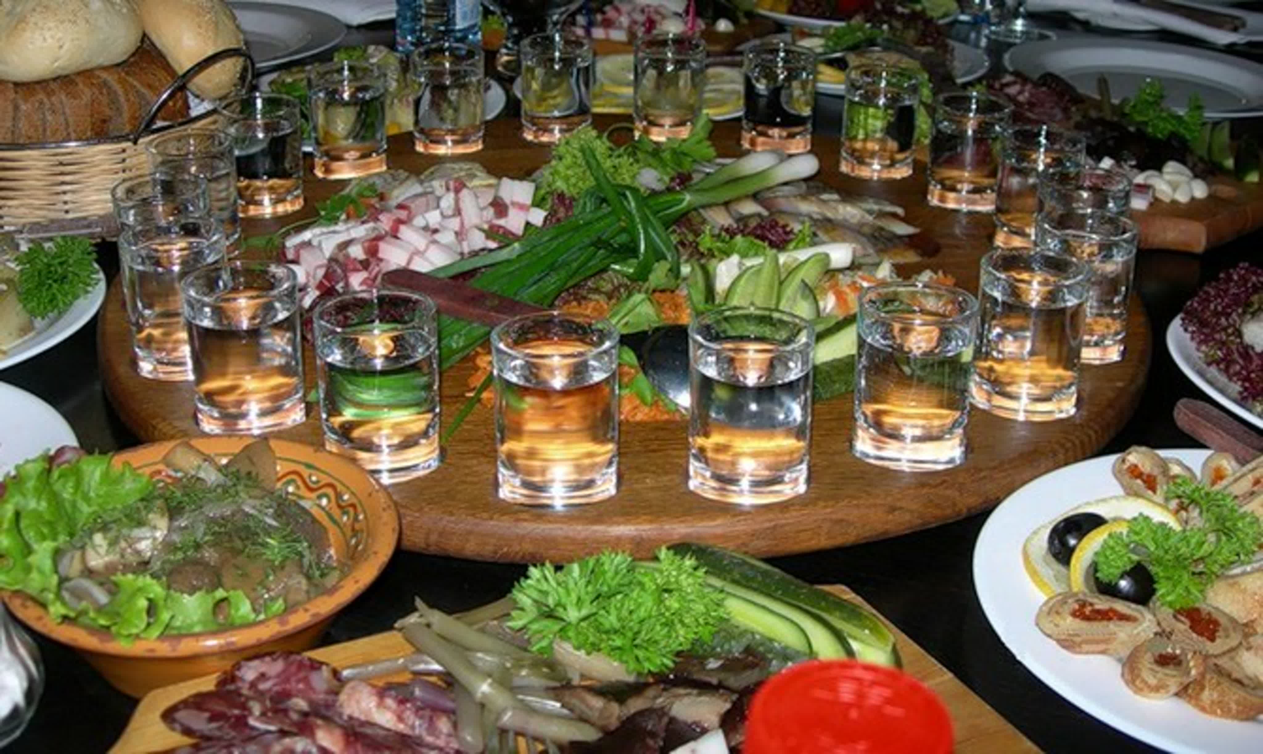 накрытый стол с едой и алкоголем дома на кухне